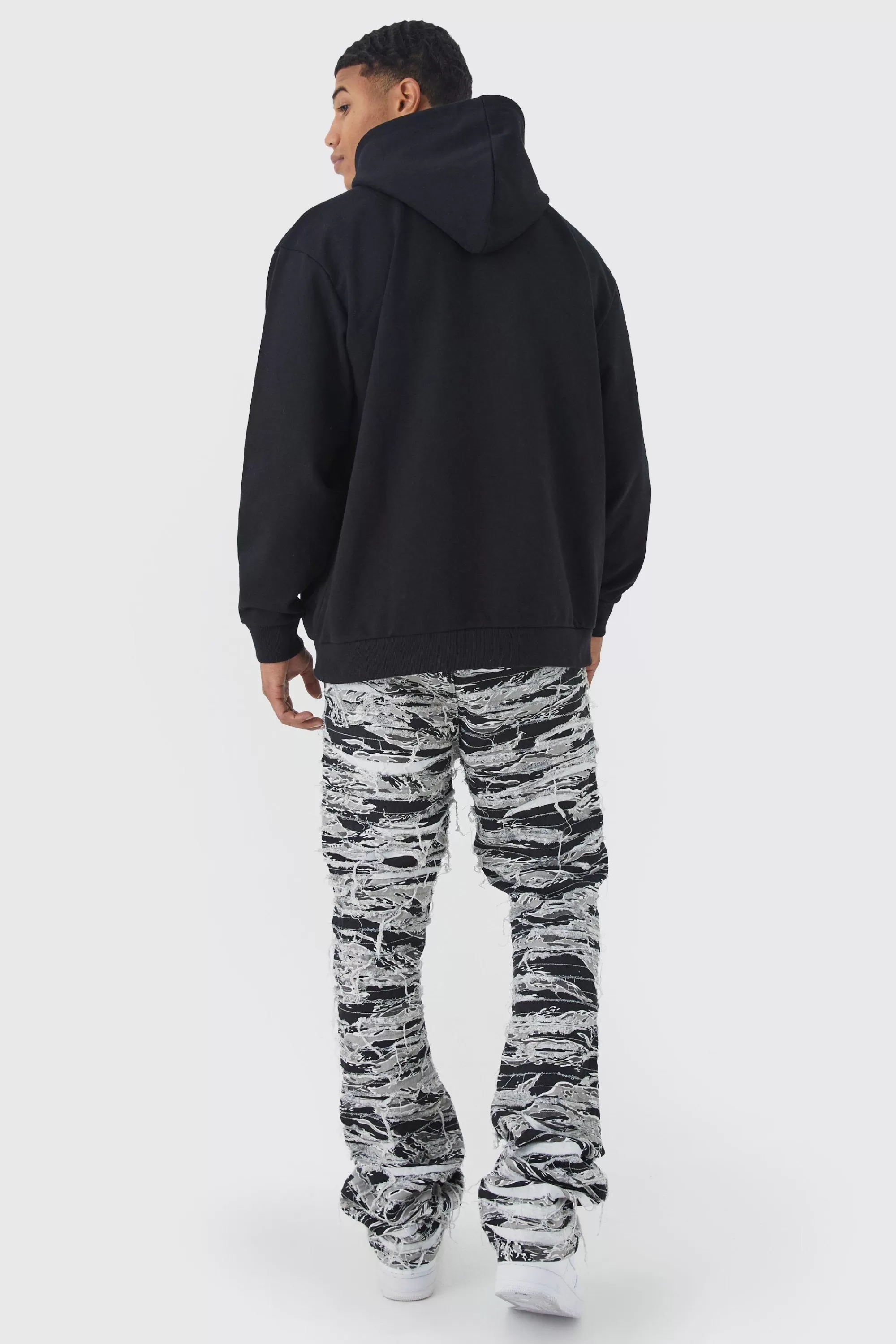 boohooMAN Slim Stacked Flare Heavily Distressed Camo Trouser | UK